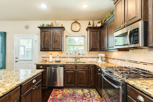 kitchen featuring sink, decorative backsplash, dark brown cabinets, and appliances with stainless steel finishes