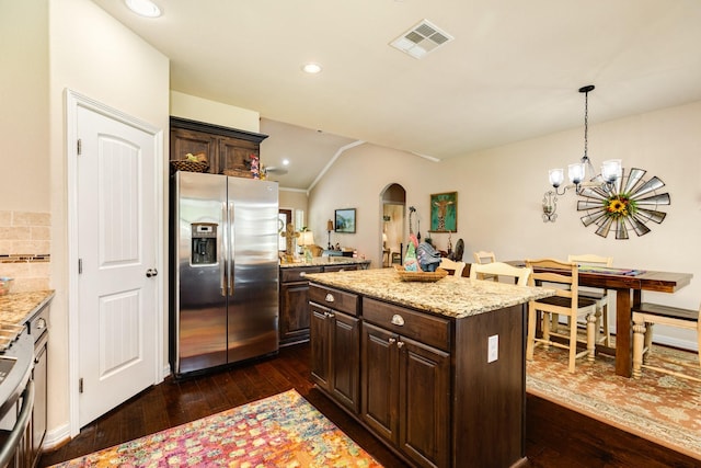 kitchen with a center island, dark brown cabinets, dark hardwood / wood-style flooring, stainless steel fridge, and pendant lighting