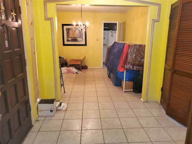 corridor with an inviting chandelier and light tile patterned floors