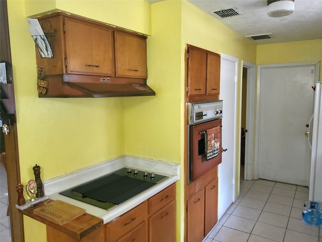 kitchen with black electric cooktop, oven, and light tile patterned floors