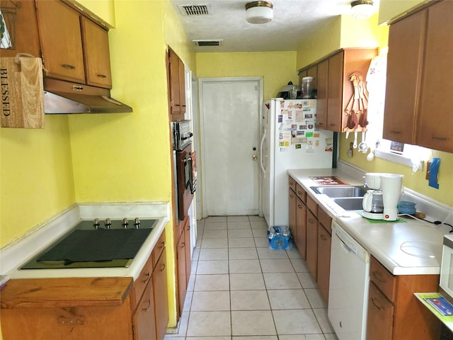 kitchen with sink, light tile patterned flooring, and white appliances