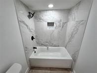 bathroom with toilet and shower / bathing tub combination