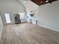 unfurnished living room featuring beamed ceiling, light hardwood / wood-style flooring, wooden ceiling, and high vaulted ceiling