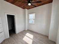 unfurnished bedroom with brick ceiling and light hardwood / wood-style flooring