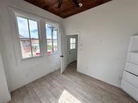 unfurnished bedroom with multiple windows and light wood-type flooring