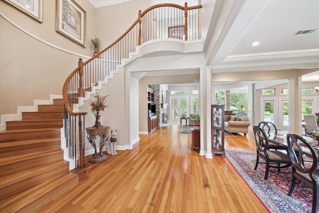 foyer entrance with a high ceiling, light wood-type flooring, and a tray ceiling