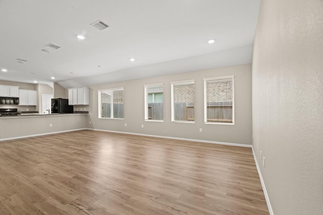 unfurnished living room featuring light wood-style floors, recessed lighting, visible vents, and baseboards