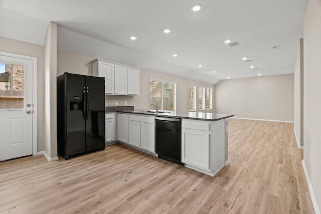 kitchen featuring white cabinets, a peninsula, light wood-type flooring, black appliances, and recessed lighting