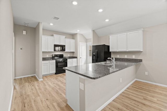 kitchen with a peninsula, a sink, visible vents, white cabinets, and black appliances