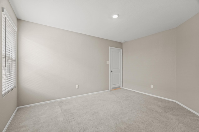 carpeted spare room with baseboards