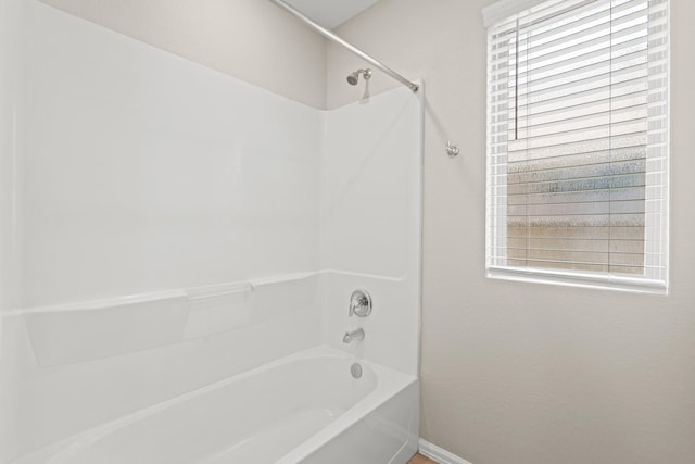 full bathroom featuring plenty of natural light, baseboards, and tub / shower combination