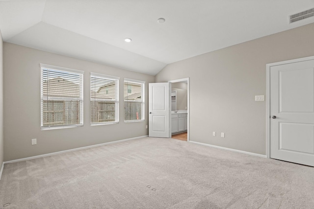 unfurnished bedroom featuring recessed lighting, light carpet, visible vents, baseboards, and vaulted ceiling