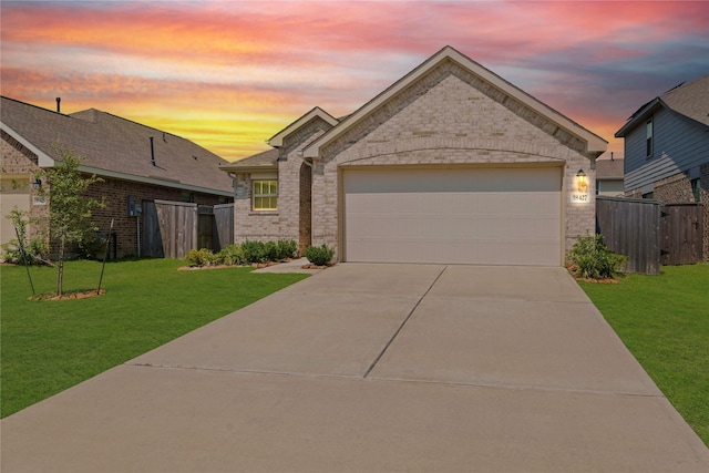 view of front of property featuring a garage, driveway, brick siding, and a front lawn