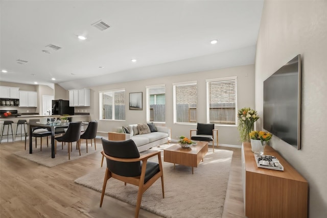 living area with lofted ceiling, light wood-style flooring, visible vents, and recessed lighting