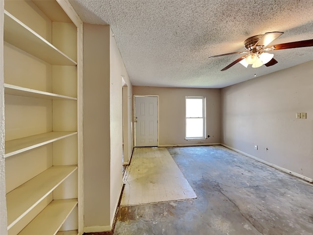 2613 34th Ave N, Texas City, TX 77590 - spare room featuring a textured ceiling, baseboards, concrete floors, and ceiling fan