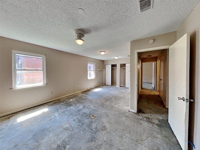 unfurnished bedroom featuring a textured ceiling and a closet