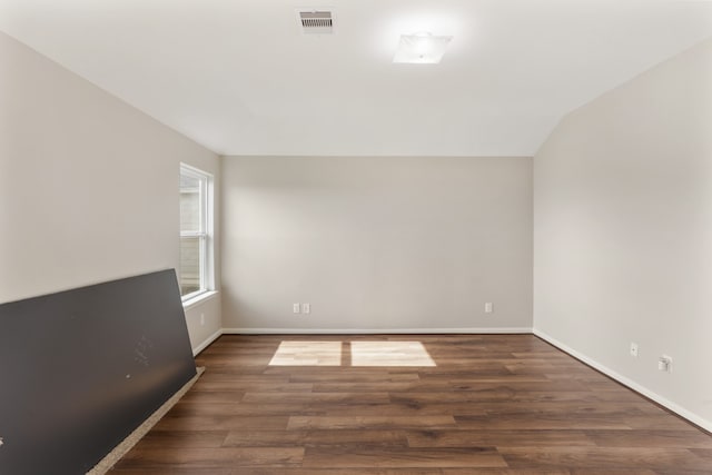 unfurnished room with lofted ceiling and hardwood / wood-style floors