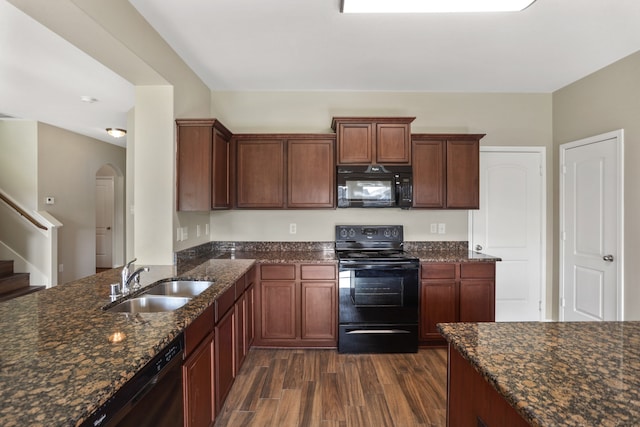 kitchen with dark stone countertops, sink, dark hardwood / wood-style floors, and black appliances