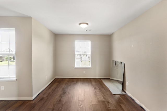 unfurnished room with plenty of natural light and dark hardwood / wood-style floors