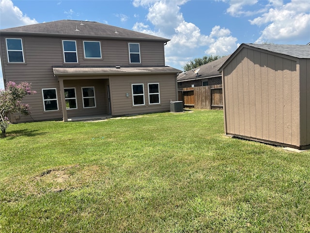 back of house featuring central AC, a lawn, and a shed