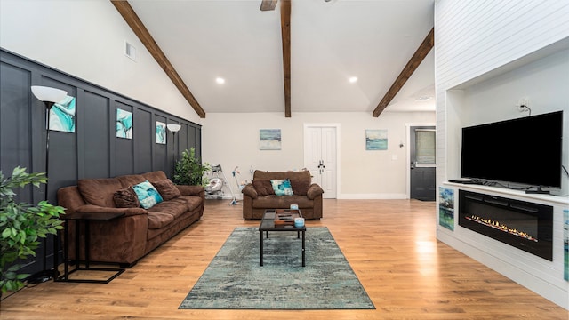 living room with high vaulted ceiling, beamed ceiling, and light wood-type flooring