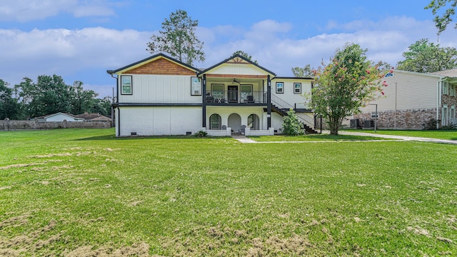 view of front of home with a balcony and a front yard