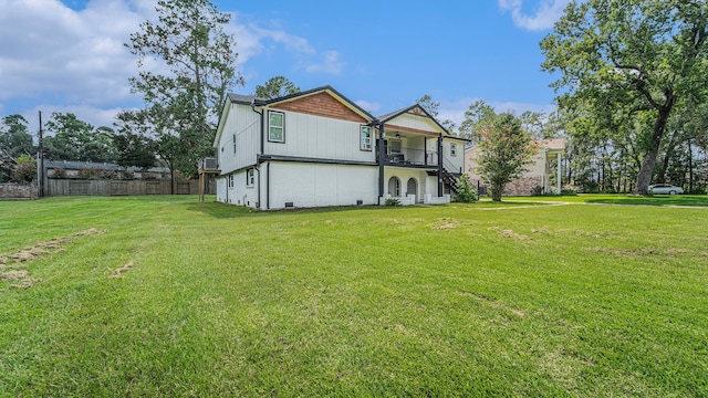 view of side of home with a balcony and a lawn