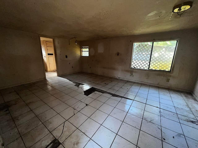 unfurnished room featuring light tile patterned flooring and plenty of natural light