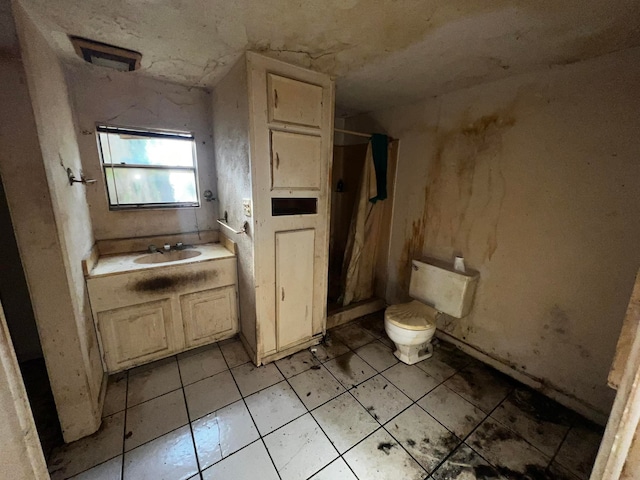 bathroom with vanity, toilet, and tile patterned floors