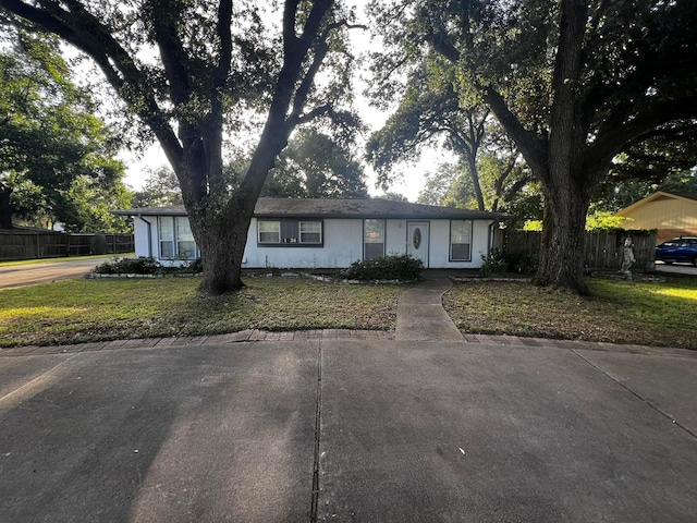 ranch-style house with a front lawn and fence