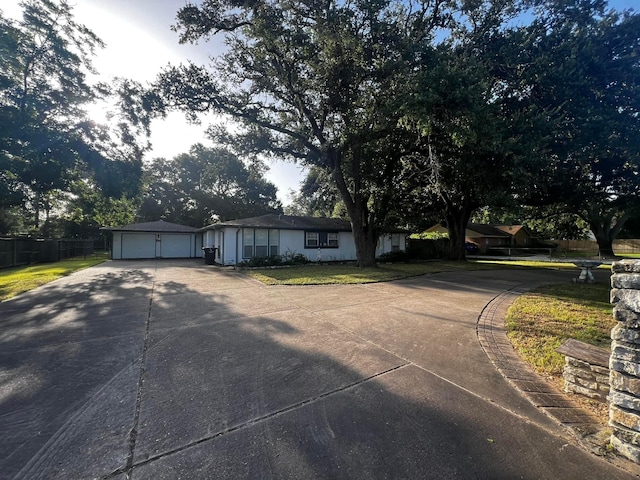 view of front of house with a garage, driveway, and fence