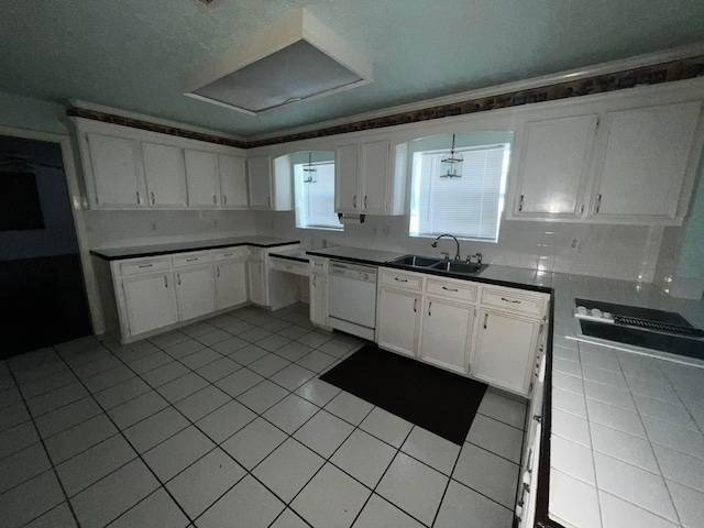 kitchen with light tile patterned flooring, a sink, white cabinetry, dishwasher, and dark countertops