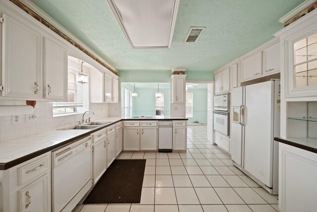 1826 E Ave, Katy, TX 77493 - kitchen featuring white appliances, a sink, a peninsula, a textured ceiling, and light tile patterned flooring