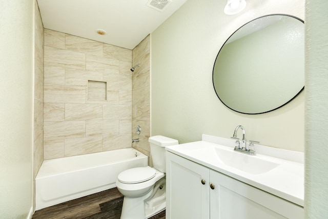 full bathroom with tiled shower / bath, wood-type flooring, toilet, and vanity