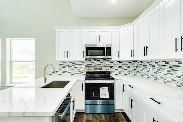 kitchen featuring light stone countertops, white cabinetry, appliances with stainless steel finishes, and sink