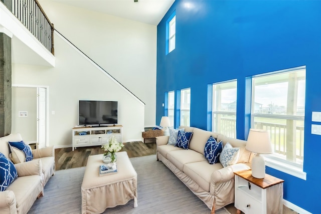 living room featuring hardwood / wood-style flooring and a towering ceiling