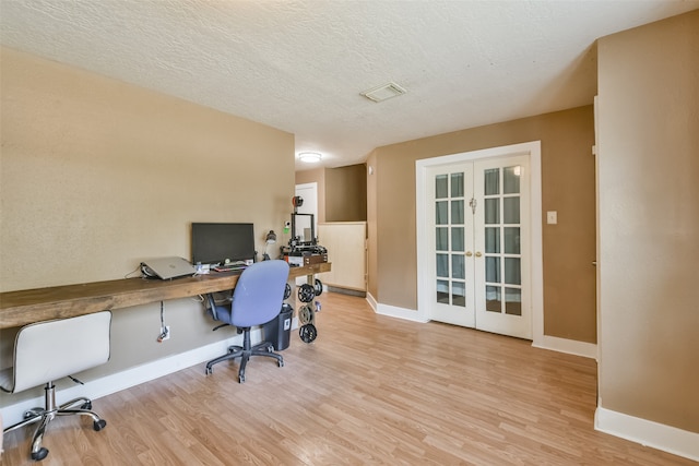 office with french doors, a textured ceiling, and light hardwood / wood-style floors