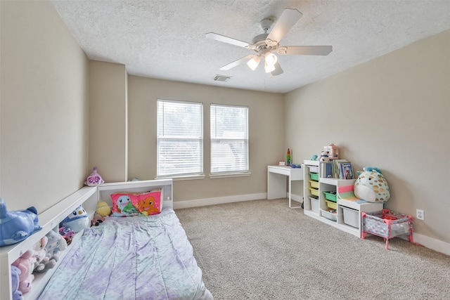 carpeted bedroom featuring ceiling fan and a textured ceiling