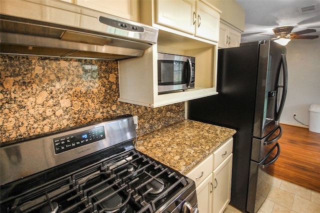 kitchen featuring appliances with stainless steel finishes, white cabinets, light tile patterned floors, and ceiling fan