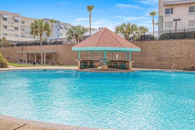 view of swimming pool featuring a pergola, an outdoor bar, and a gazebo