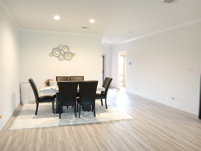 dining area with light wood-type flooring and crown molding