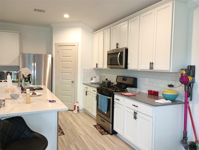 kitchen featuring decorative backsplash, stainless steel appliances, and white cabinetry