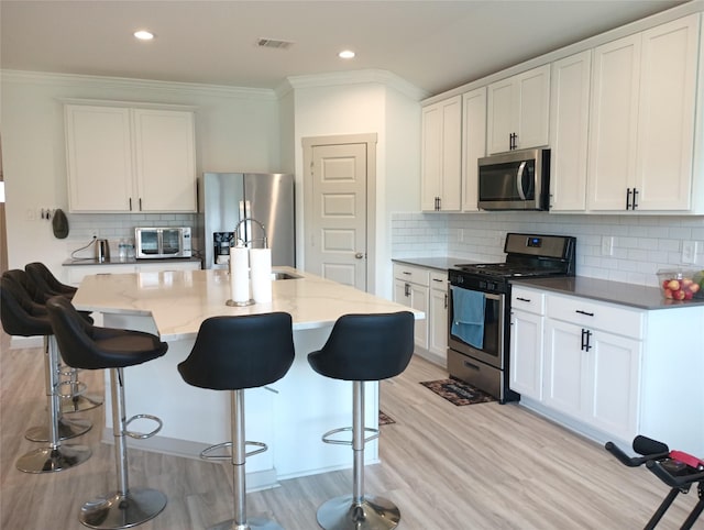 3335 Balboa Grove Ln, Missouri City, TX 77459 - kitchen with light stone countertops, light wood-type flooring, visible vents, stainless steel appliances, and backsplash