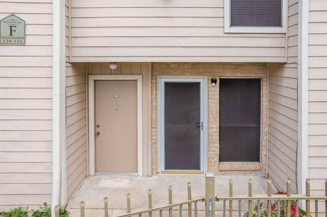 view of exterior entry featuring fence