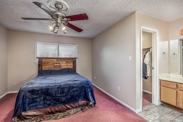 bedroom featuring a textured ceiling, light colored carpet, and ceiling fan