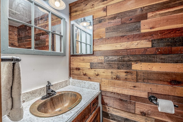 bathroom featuring vanity and wooden walls