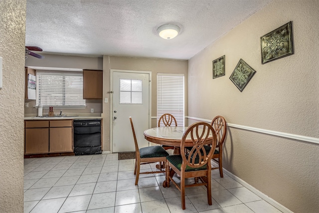 tiled dining space featuring sink, a textured ceiling, and ceiling fan