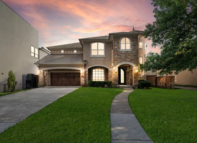 view of front of home with a garage and a yard