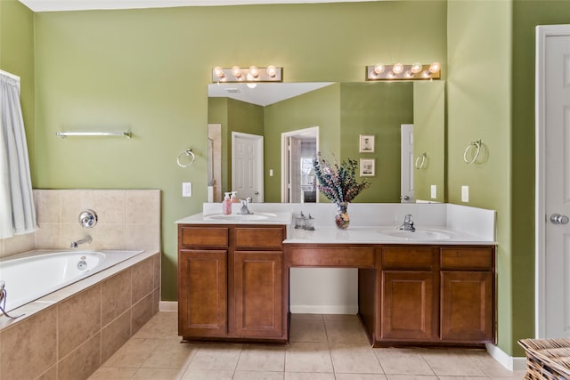 bathroom featuring tiled tub, vanity, and tile patterned flooring