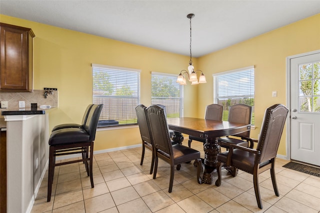 dining area featuring plenty of natural light, an inviting chandelier, and light tile patterned flooring